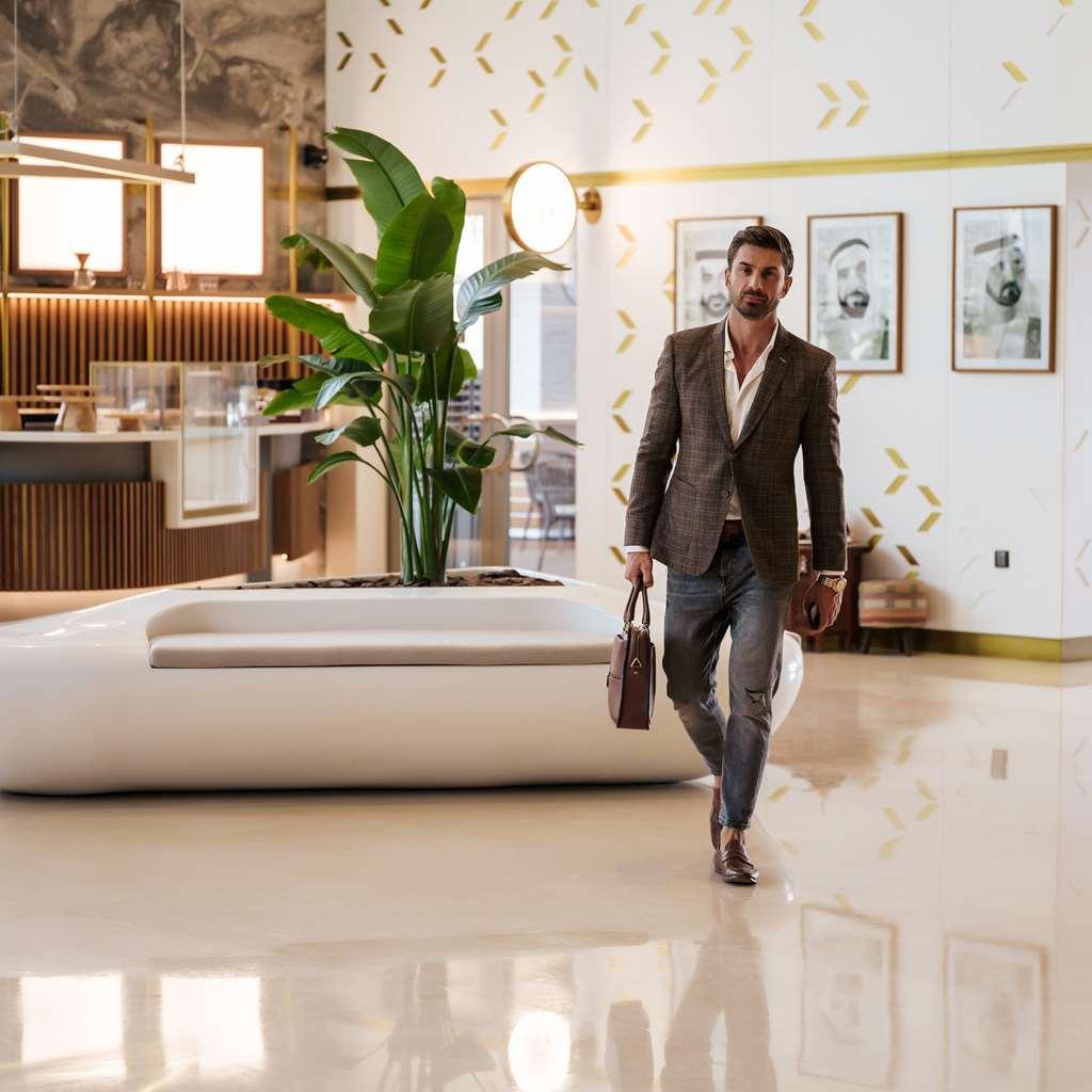 Hotel The First Collection Dubai Business Bay Interno foto A man walking through a lobby